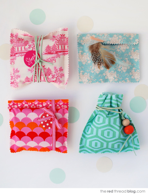Close-up of handmade fabric gift bags in various pastel colors, tied with ribbons, showcasing a tutorial for crafting charming gift packaging.