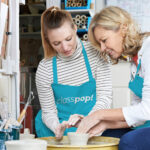 Two women enjoying a pottery class, a unique birthday gift idea for wife, fostering creativity and shared experiences