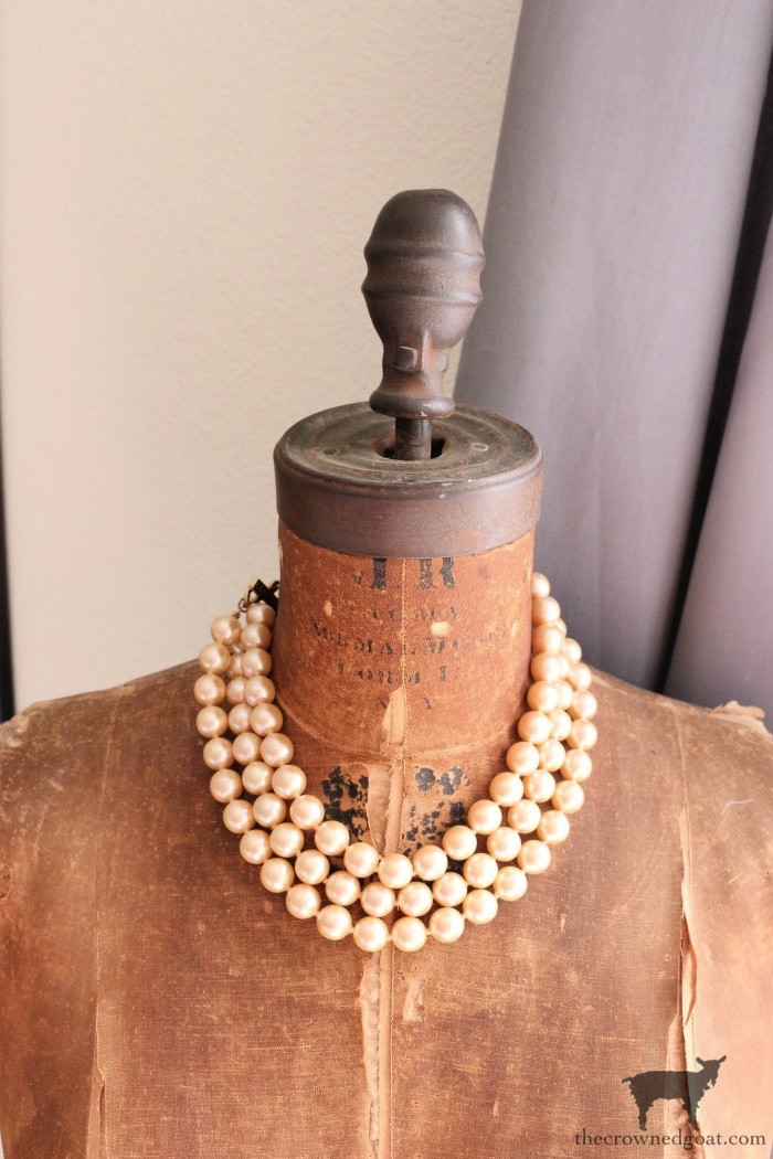 A close-up of a three-strand vintage necklace, showcasing its delicate beads and classic design, emphasizing its affordability and timeless appeal.