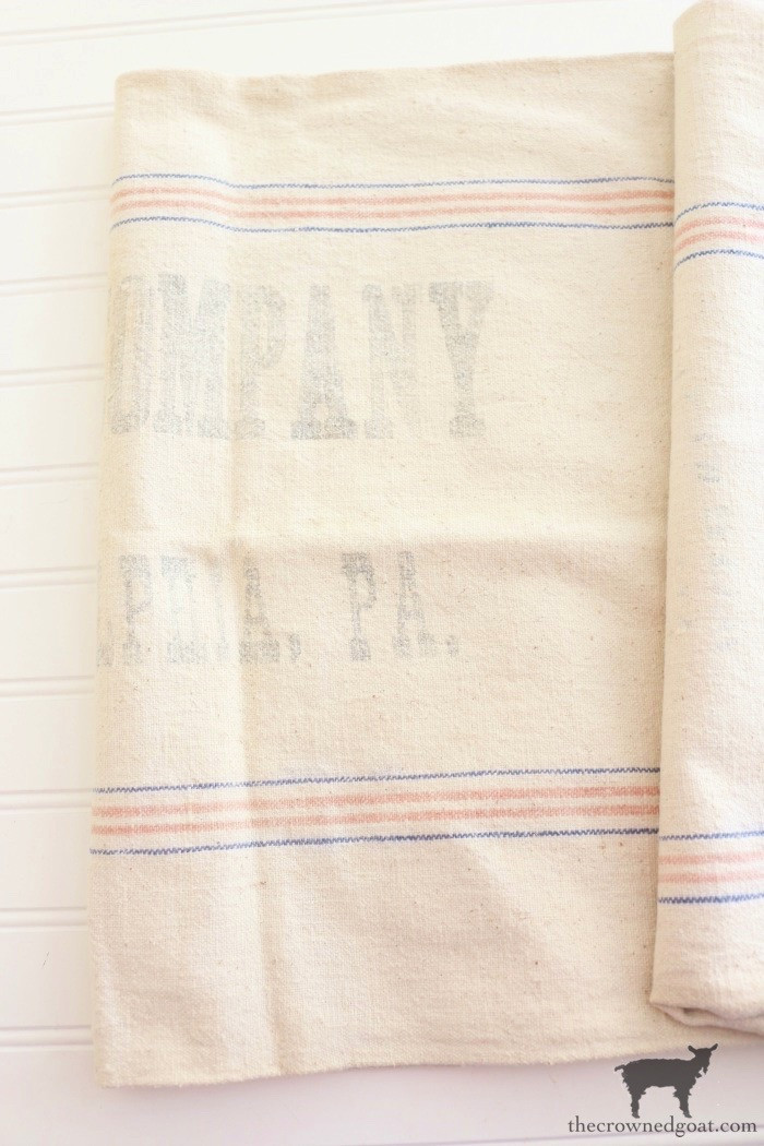 A vintage grain sack with bold stripes, possibly repurposed as a decorative item, highlighting its rustic charm and historical significance.