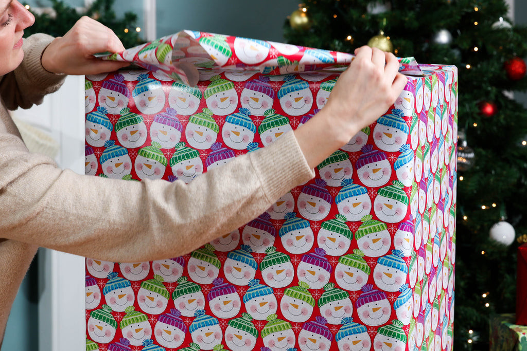 Folding the wrapping paper into a triangle shape at the end of the box for a clean finish.