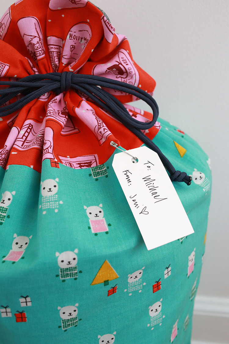 Plain paper gift tags attached to drawstring bags