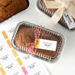 Mini foil loaf pans with banana bread and gift tag wrapped around that says