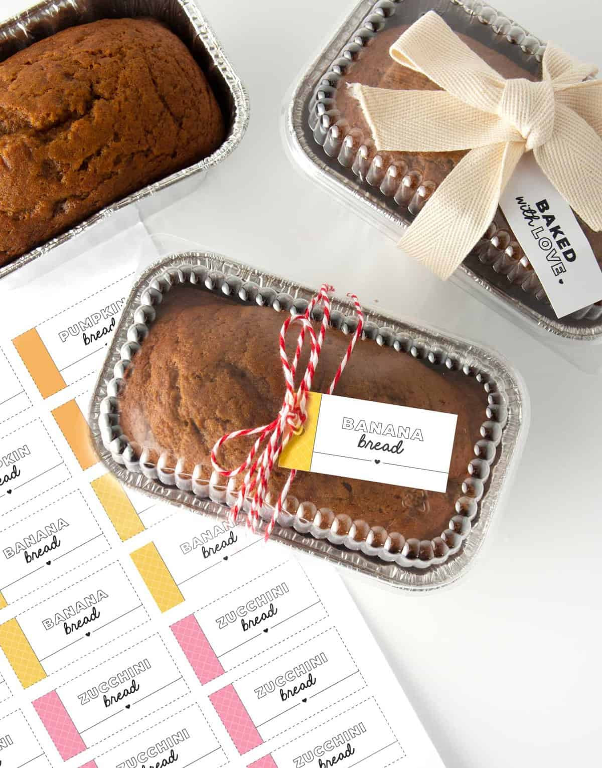 Mini foil loaf pans with banana bread and gift tag wrapped around that says