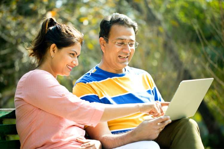 adult couple playing game on computer outdoors